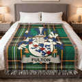 Fulton family crest on a green plaid blanket with white fringe.
