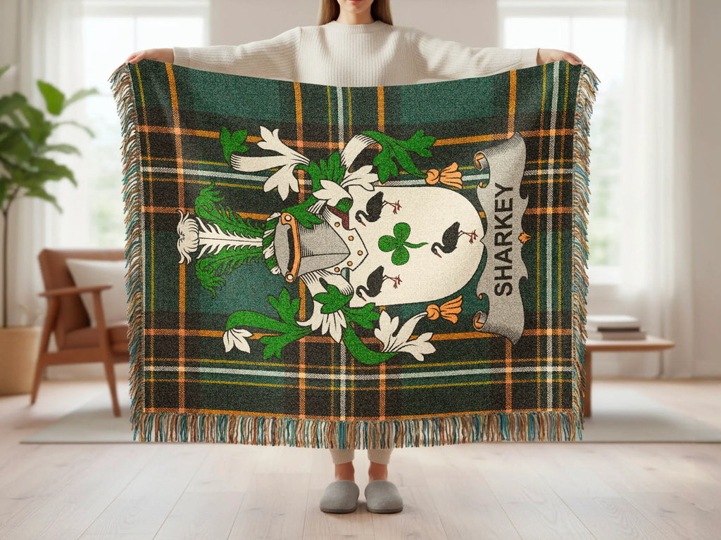 Tartan throw blanket with Sharkey family crest and fringed edges.