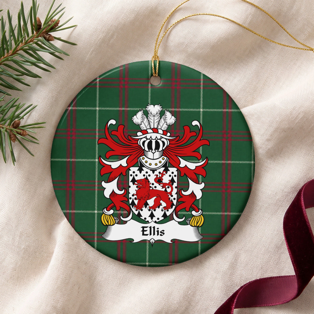 Ellis ornament on cream fabric beside evergreen and burgundy ribbon; a red walking lion on a white shield patterned with black ermine marks on Welsh national tartan.