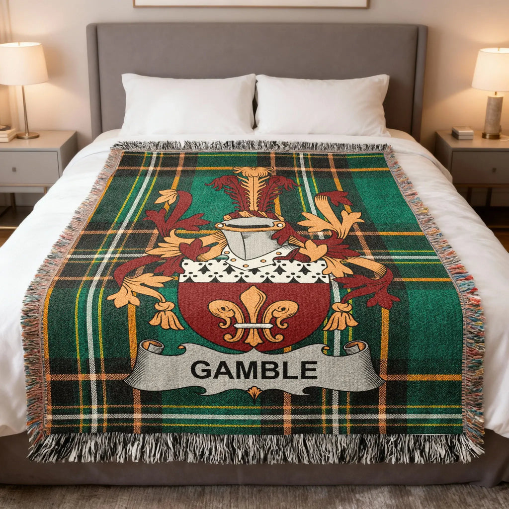 Tartan blanket with Gamble family crest on a bed.