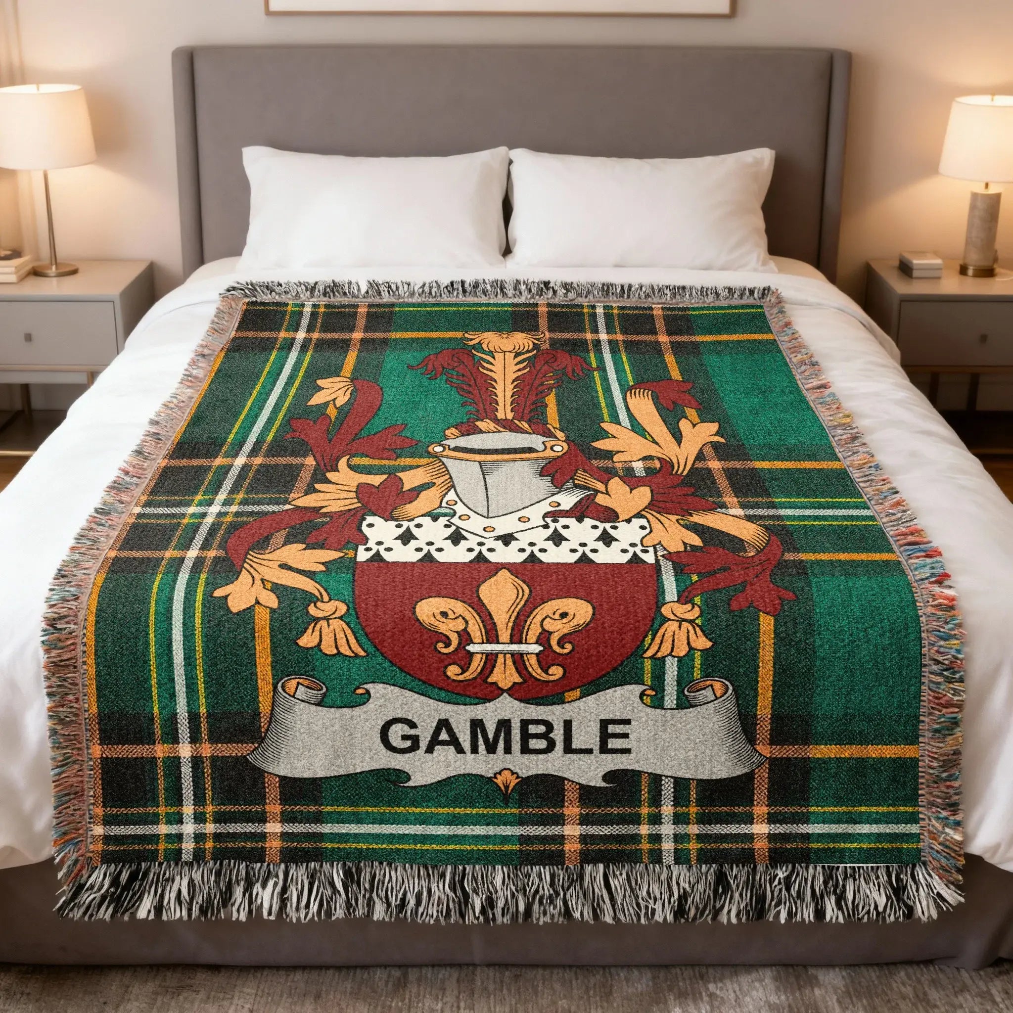 Tartan blanket with Gamble family crest on a bed.