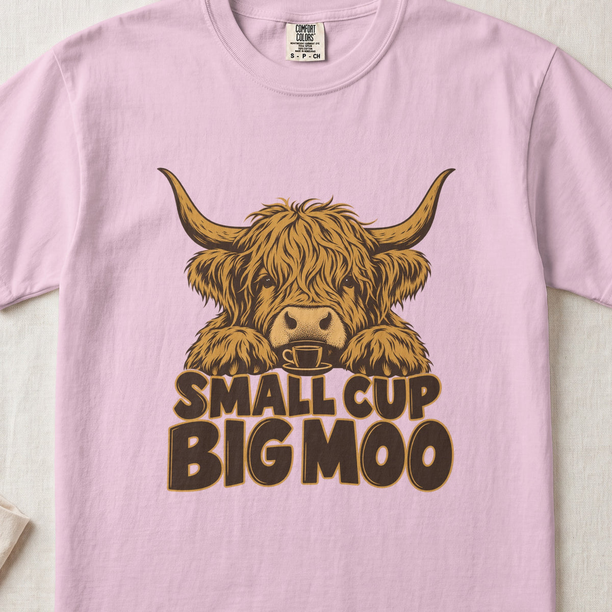Small Cup, Big Moo Highland cow design on a Blossom Comfort Colors 1717 T-shirt, flat lay