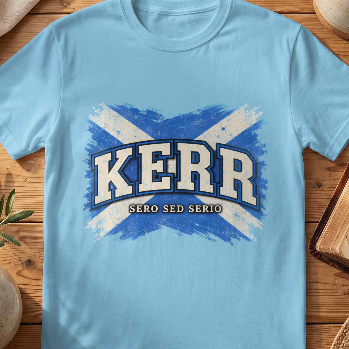 Kerr Scottish Saltire T-shirt in Sky, with distressed blue and cream flag and “Sero Sed Serio” lettering.