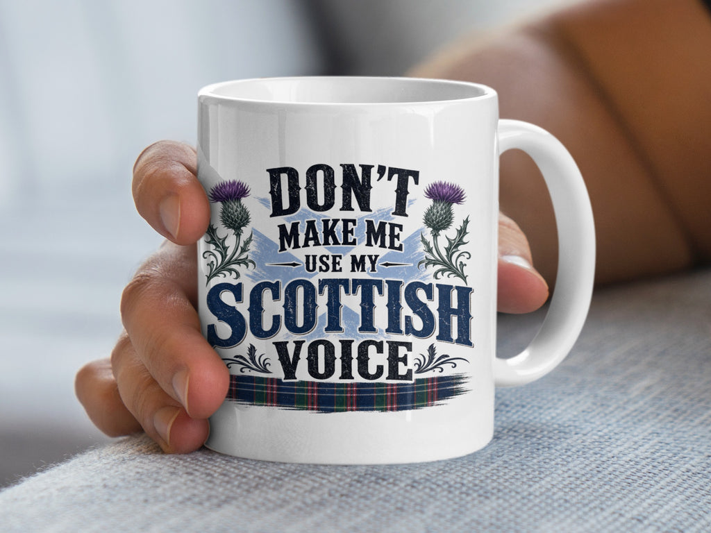 White mug with "Don't make me use my Scottish voice" text and thistle design.