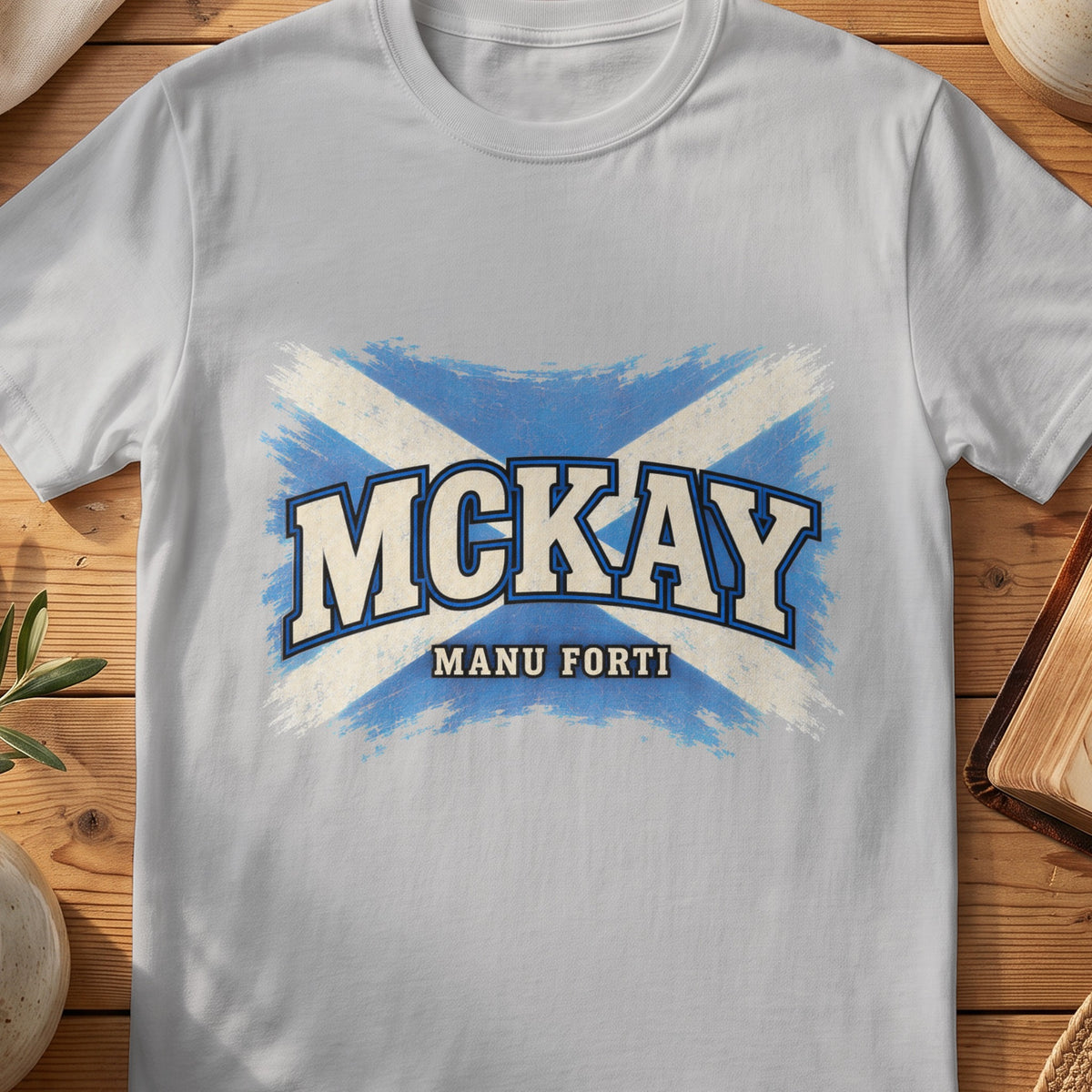 McKay Scottish Saltire T-shirt in Sport Grey, with distressed blue and cream flag and “Manu Forti” lettering.