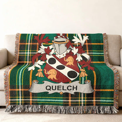 Green plaid throw blanket with a coat of arms and the name QUELCH.