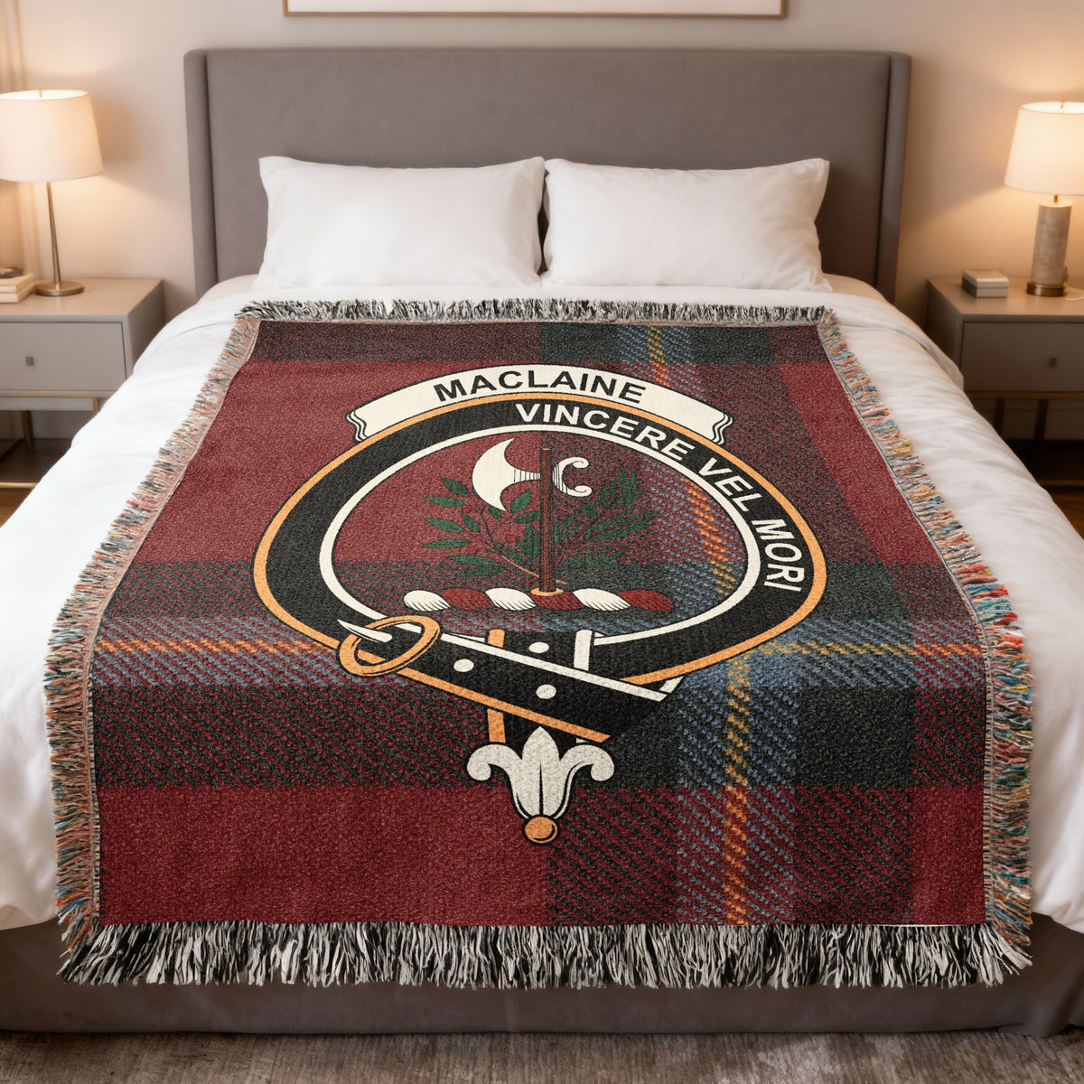 MacLaine of Lochbuie woven blanket displayed on a bed, with a battleaxe between leafy branches on a red, grey and dark green tartan background