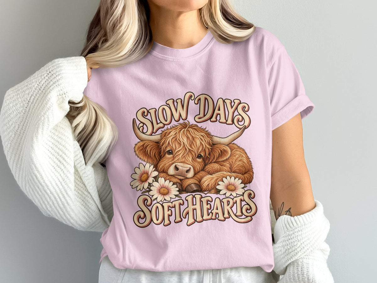 Model wearing the Slow Days, Soft Hearts Highland cow Comfort Colors T-shirt in Blossom