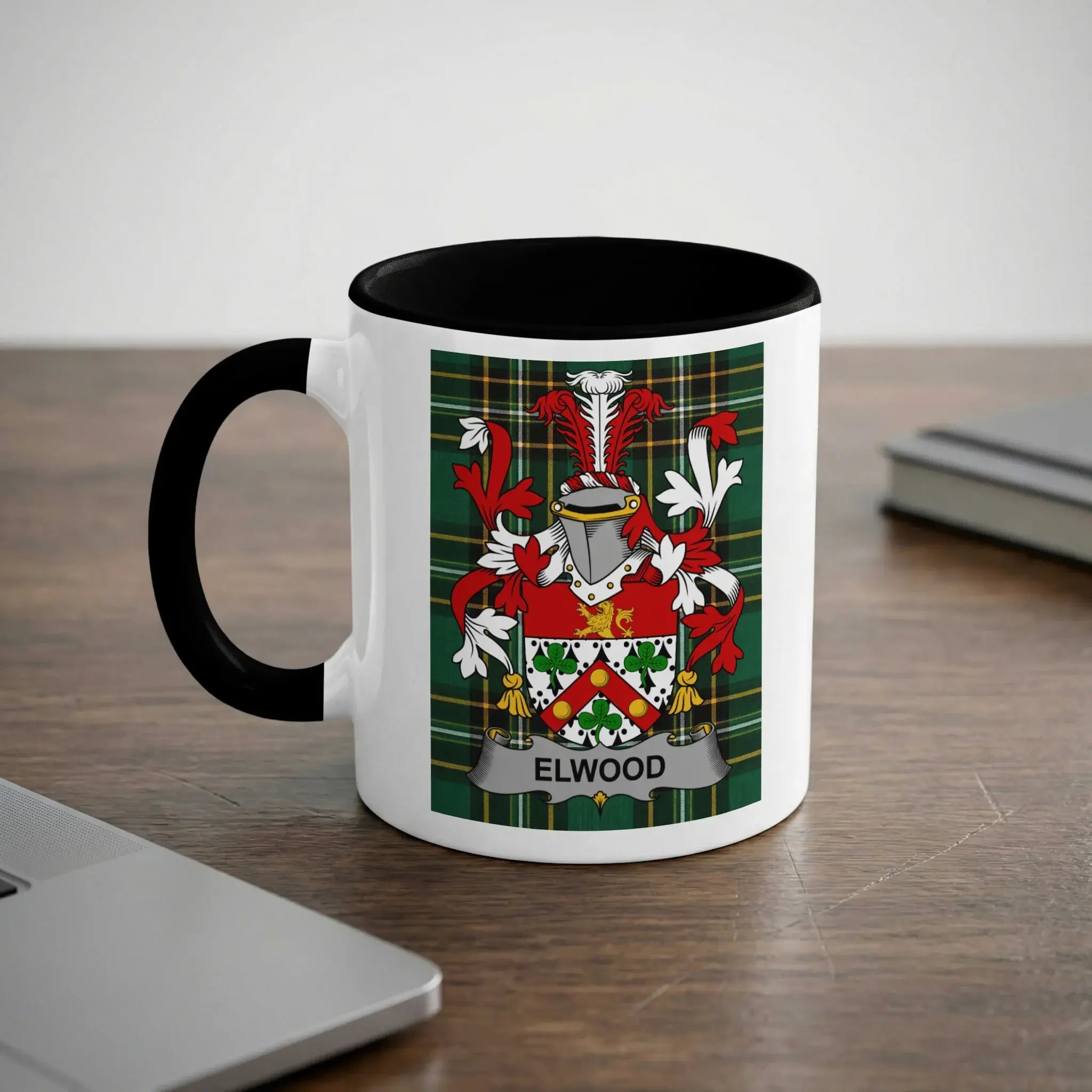 White mug with black rim featuring Elwood family crest on plaid background.