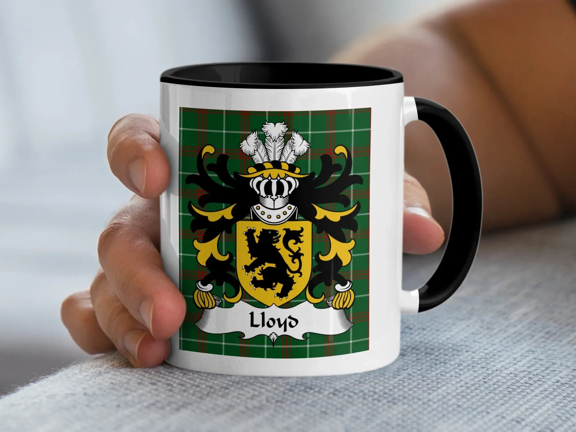 Lloyd Welsh coat of arms accent mug with black handle held in hand on Welsh National Tartan