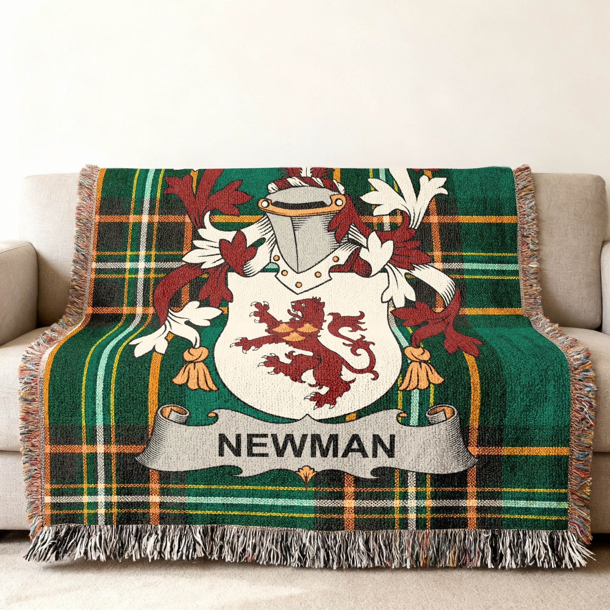 Green tartan blanket with Newman family crest displayed on a sofa.