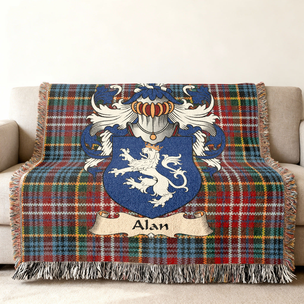 Alan Scottish family shield woven blanket with Caledonia tartan background on a sofa