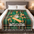 Green plaid blanket with GRUMLEY family crest on a bed.