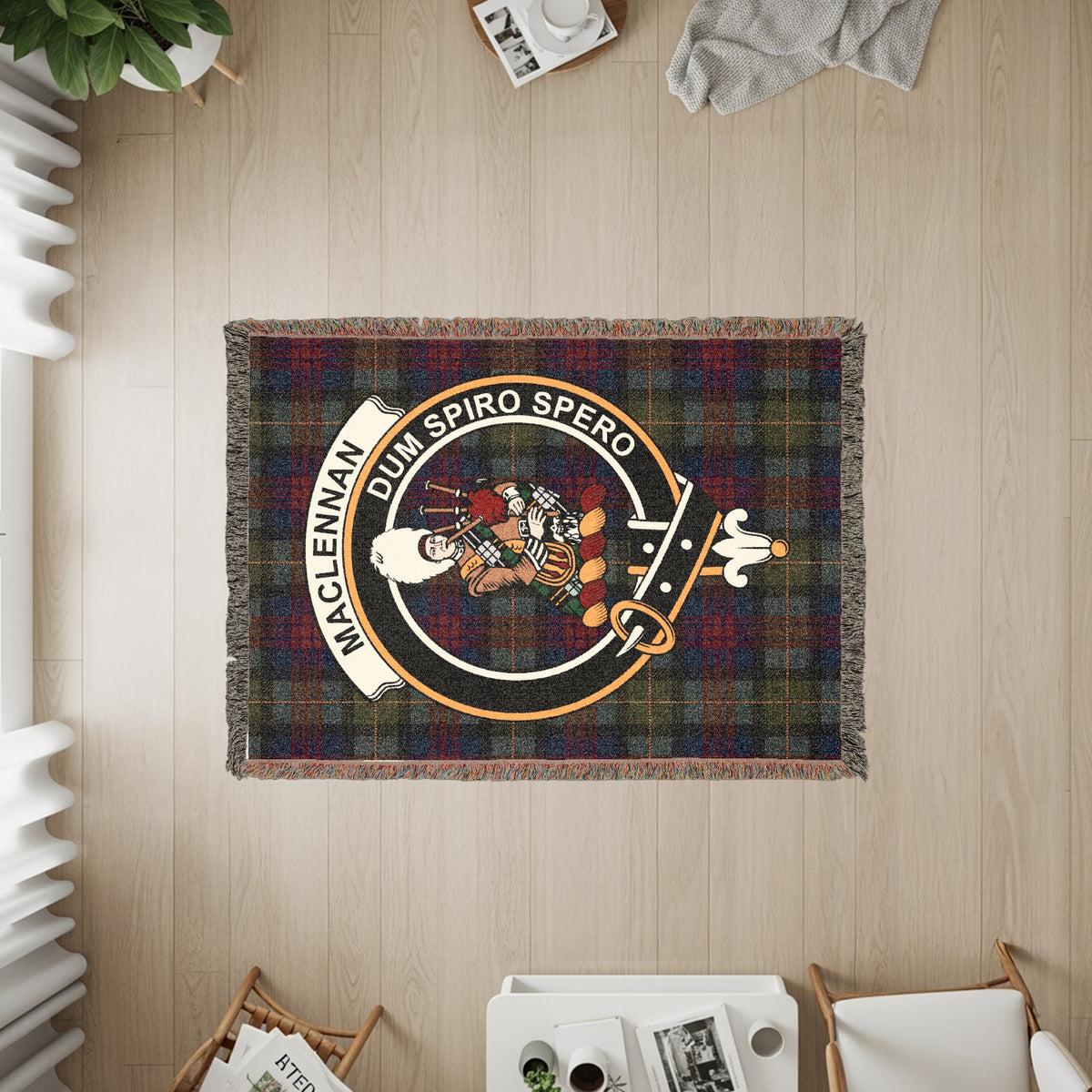 MacLennan woven blanket displayed on a wall, featuring the crest badge and tartan background