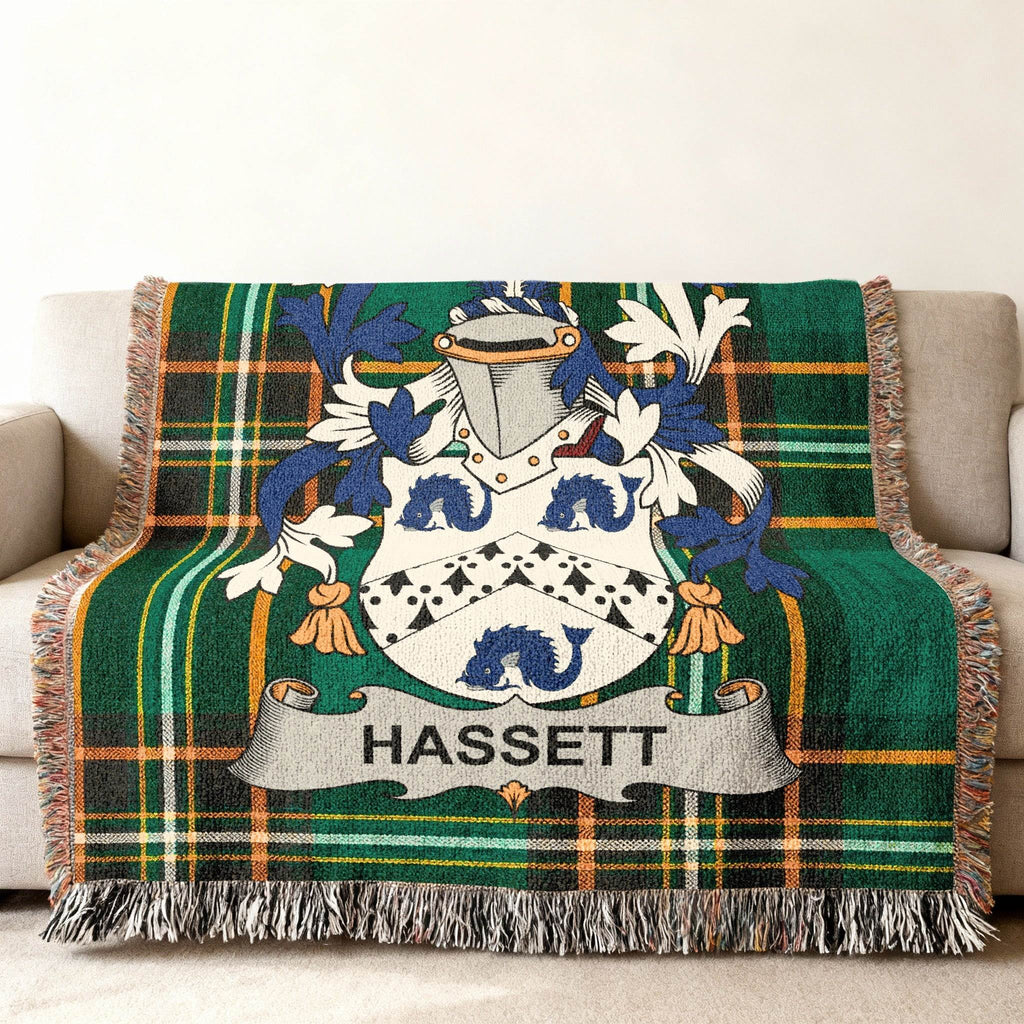 Green plaid blanket with "HASSETT" family crest on a couch.