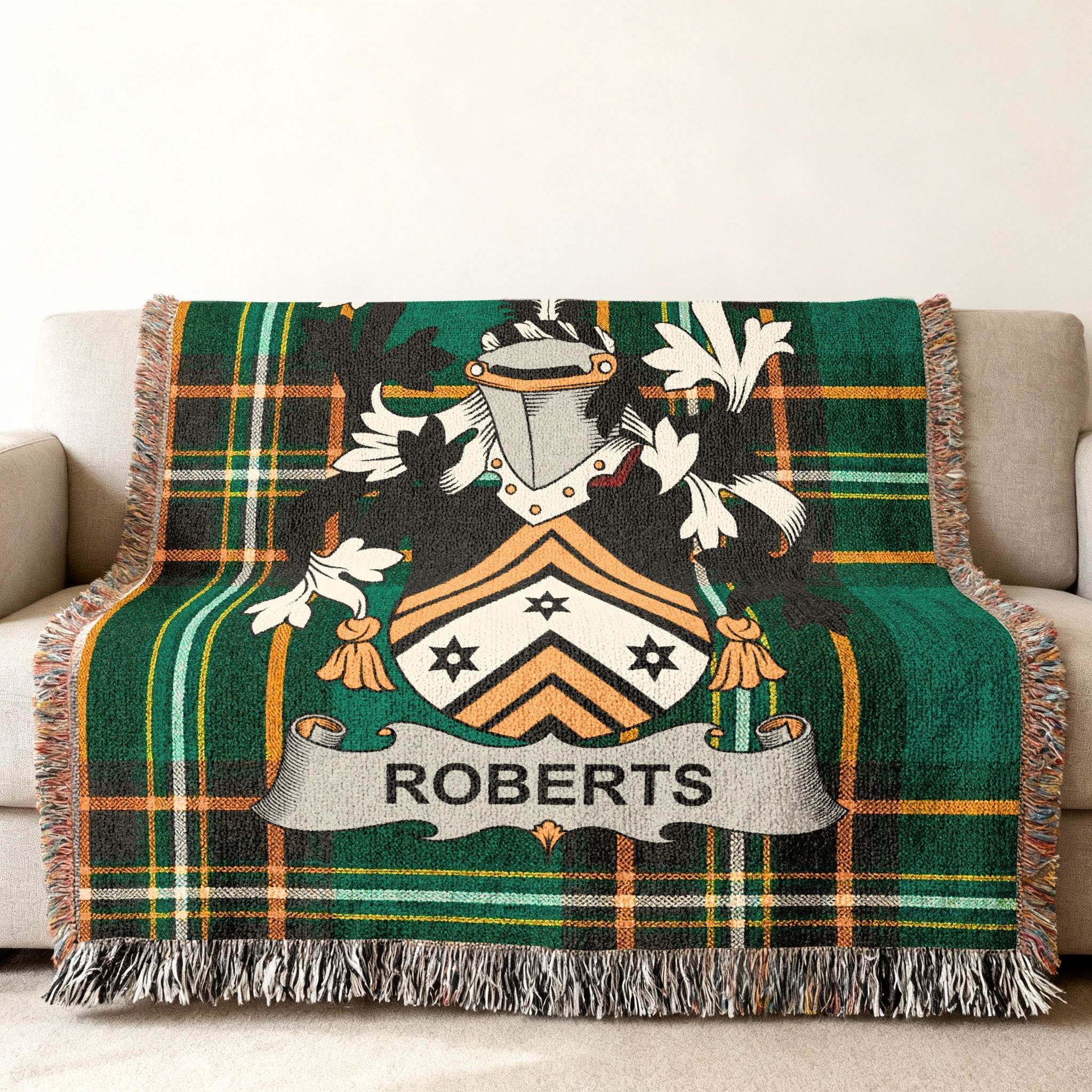 Green tartan blanket with Roberts family crest on a sofa.