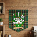 Connell family crest on green plaid banner hanging on a wooden wall.