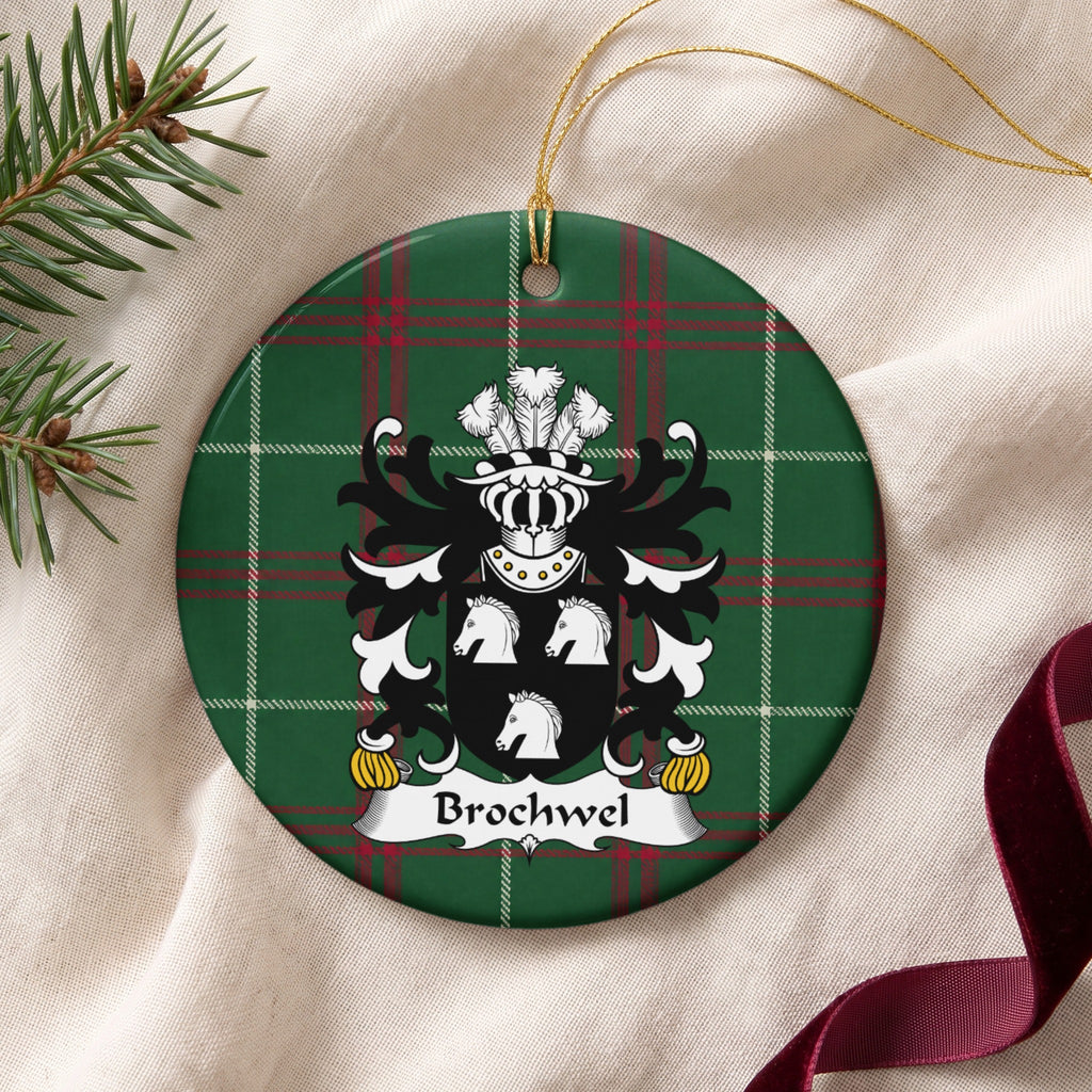Brochwel Style 1 ornament on cream fabric with gold string, evergreen and burgundy ribbon; three white horse heads on a black shield on Welsh national tartan.