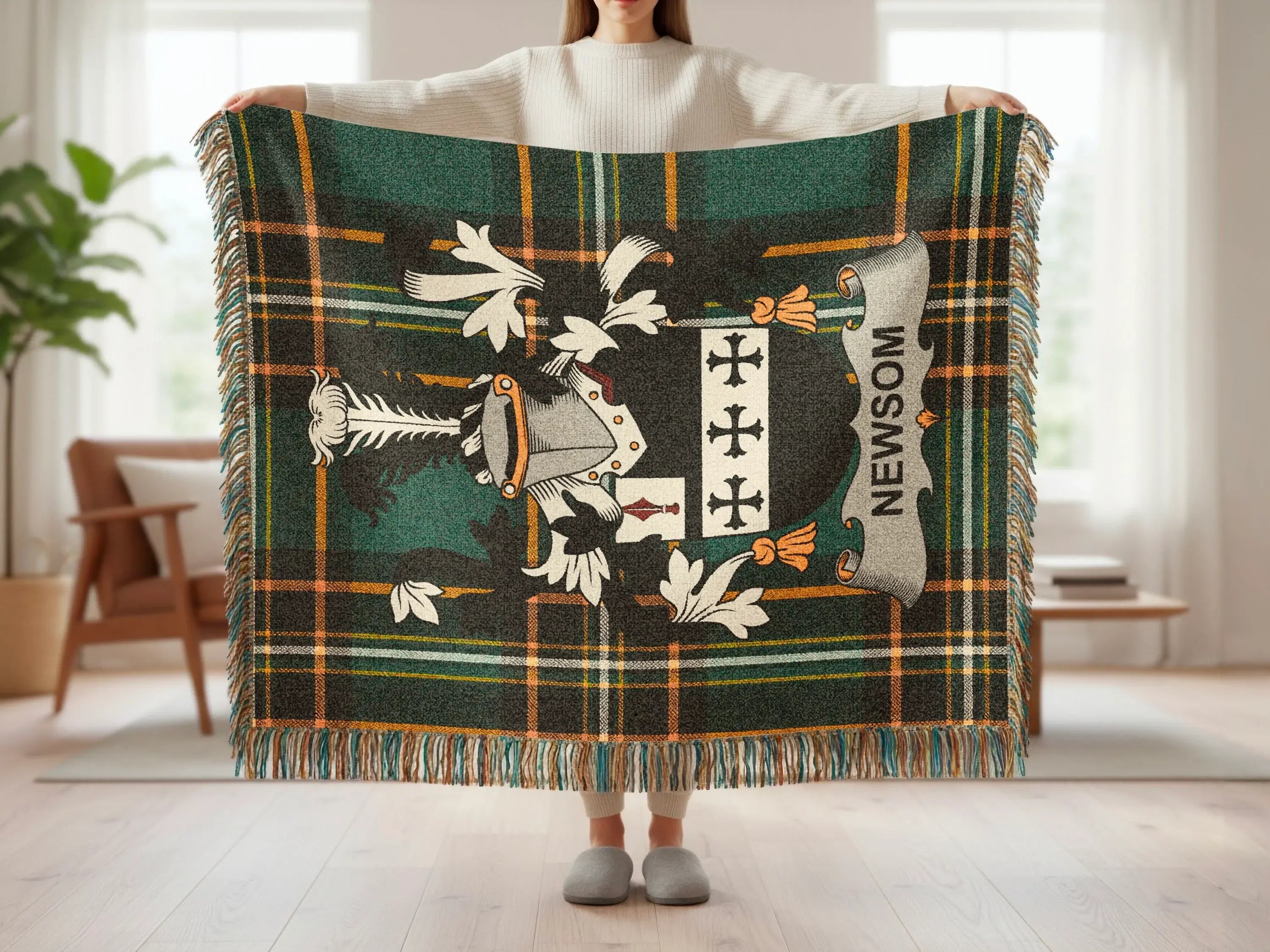 Newsom family crest on a dark green and orange plaid throw blanket.