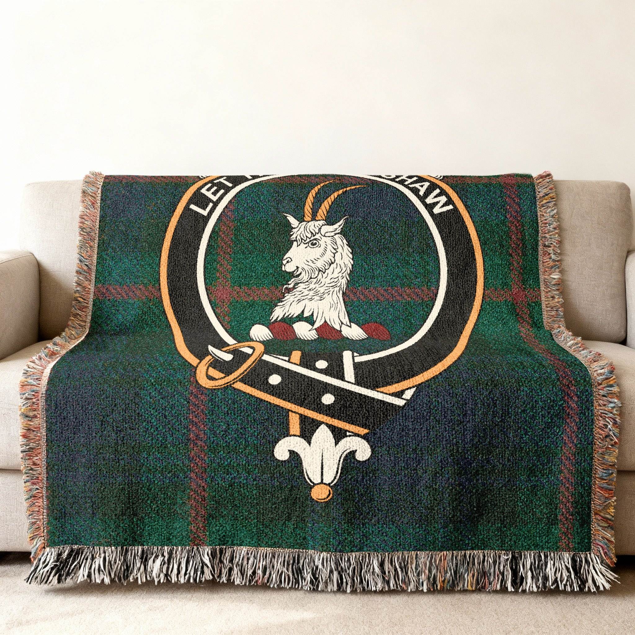 Fleming woven blanket draped over sofa — 60x50 size, fringe edges and tartan with goat crest detail