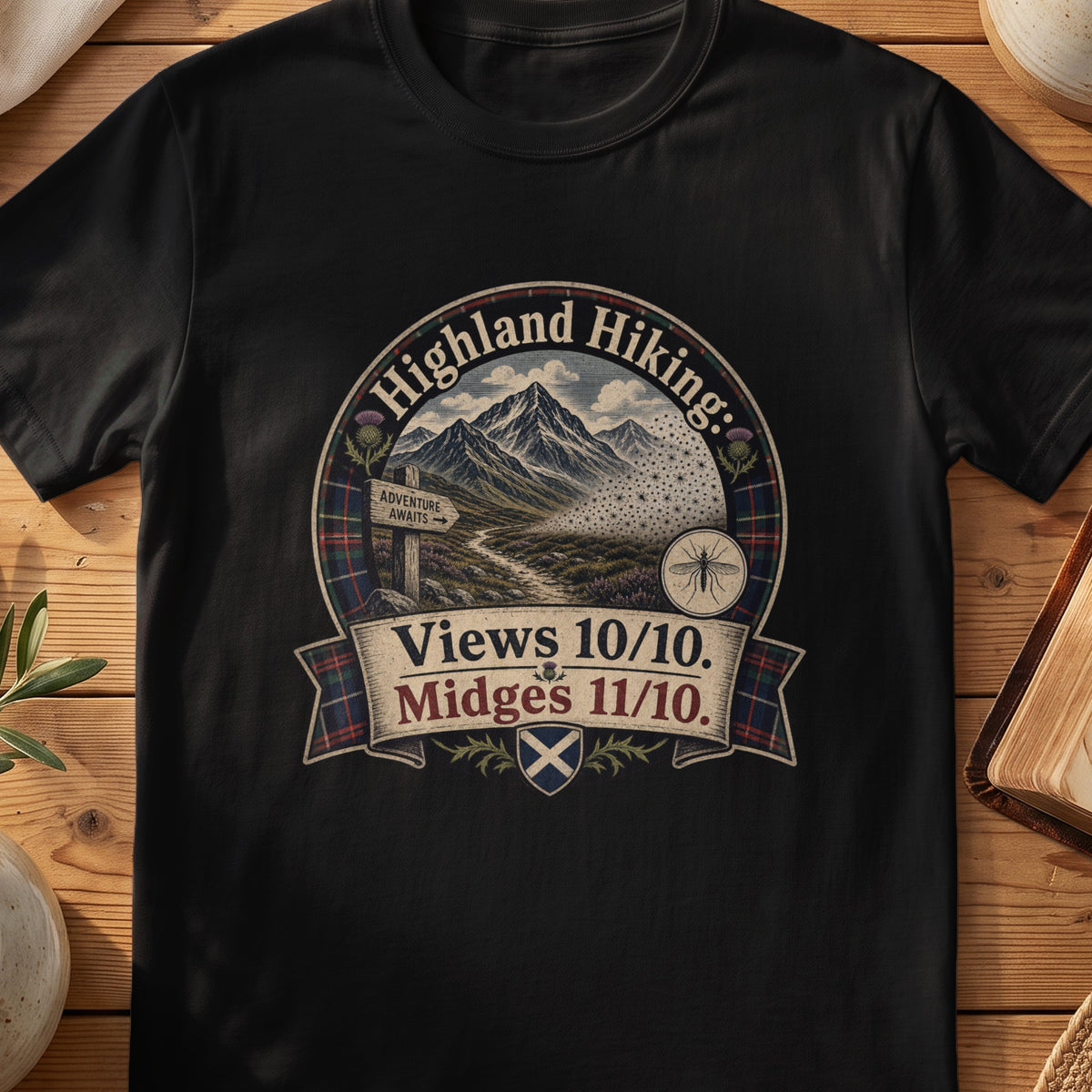 Black Gildan 64000 unisex T-shirt flatlay with Highland Hiking Midges Scottish graphic design