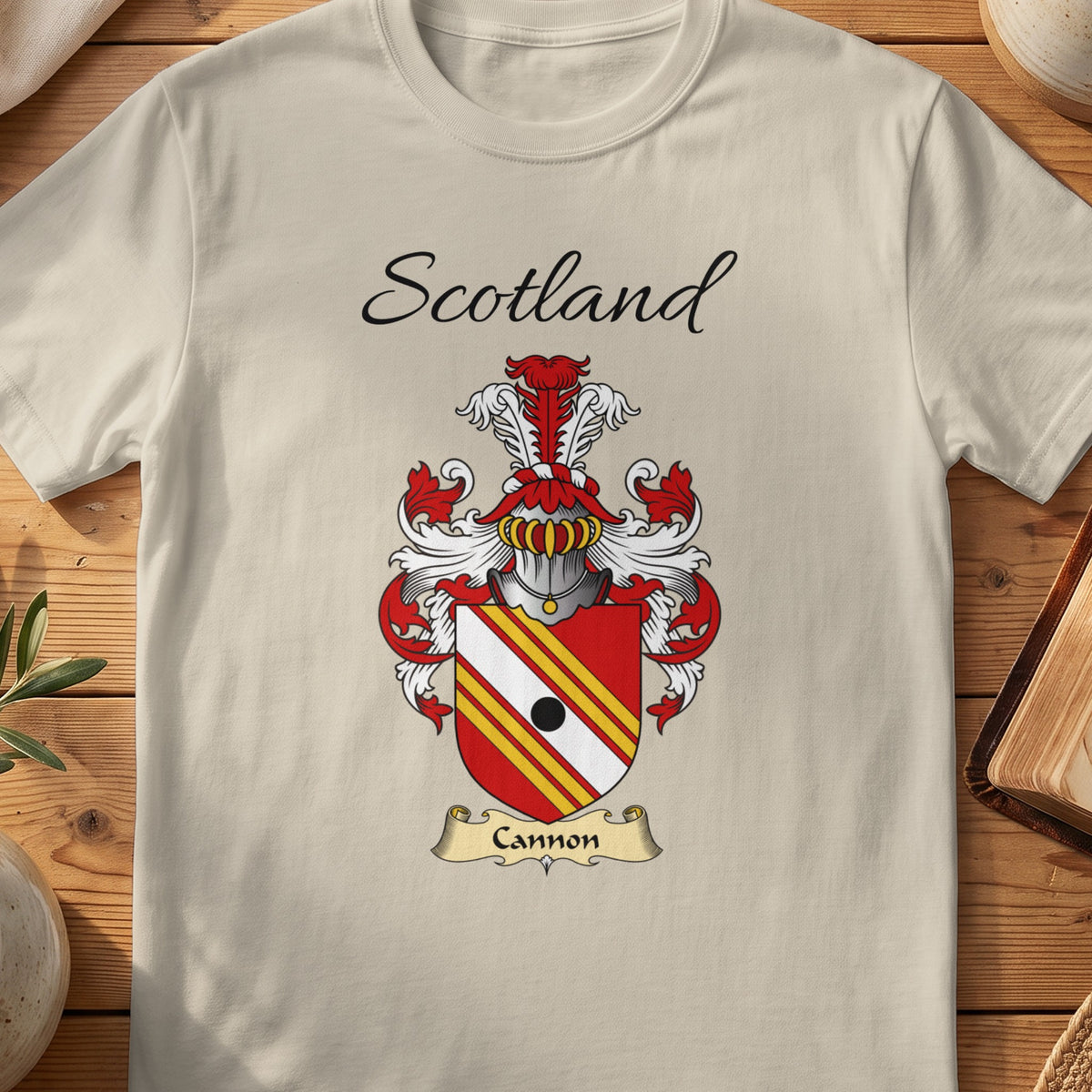 Sand Cannon Scottish family shield T-shirt featuring red-and-gold diagonal stripes with a black roundel