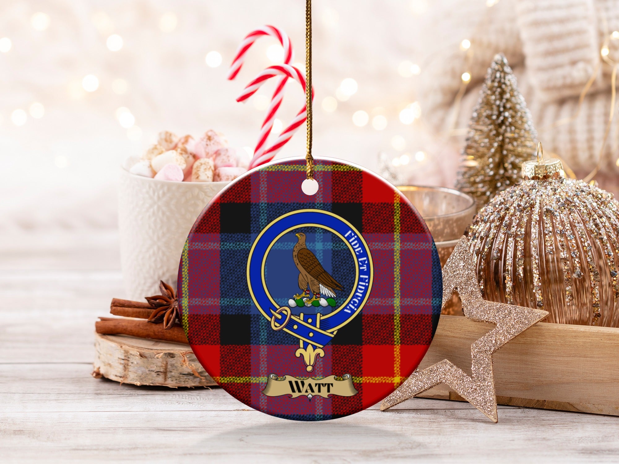 Watt clan crest with eagle and motto on round tartan ornament with holiday decor