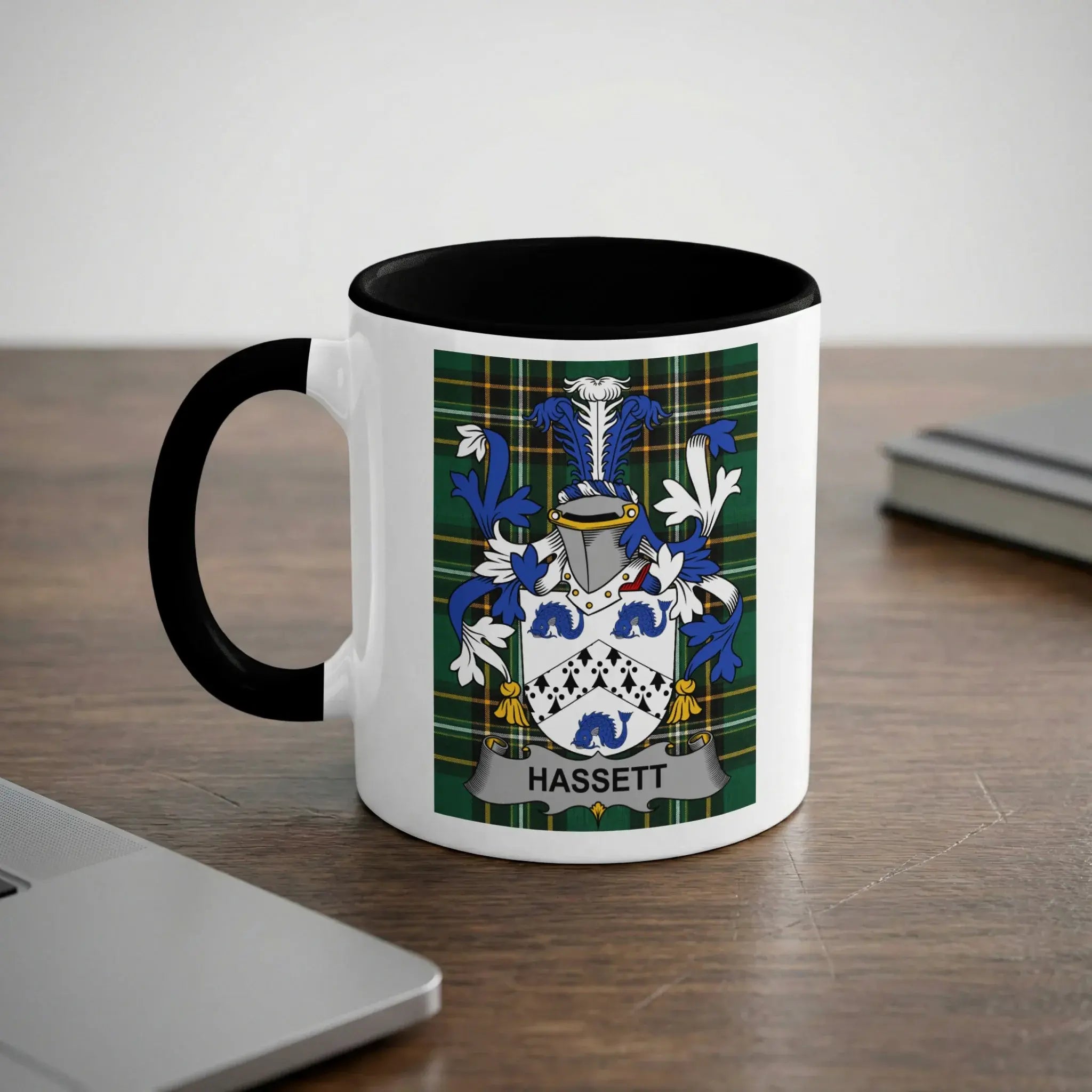 White mug with black rim featuring the Hassett family crest on a plaid background.