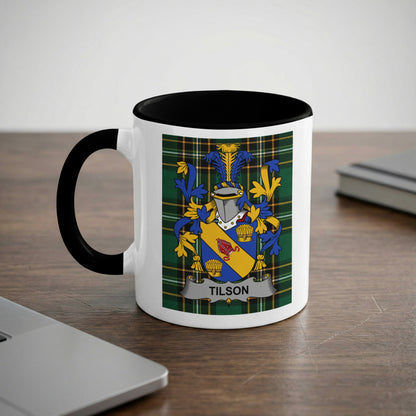 White mug with black rim featuring the Tilson family crest on the side.