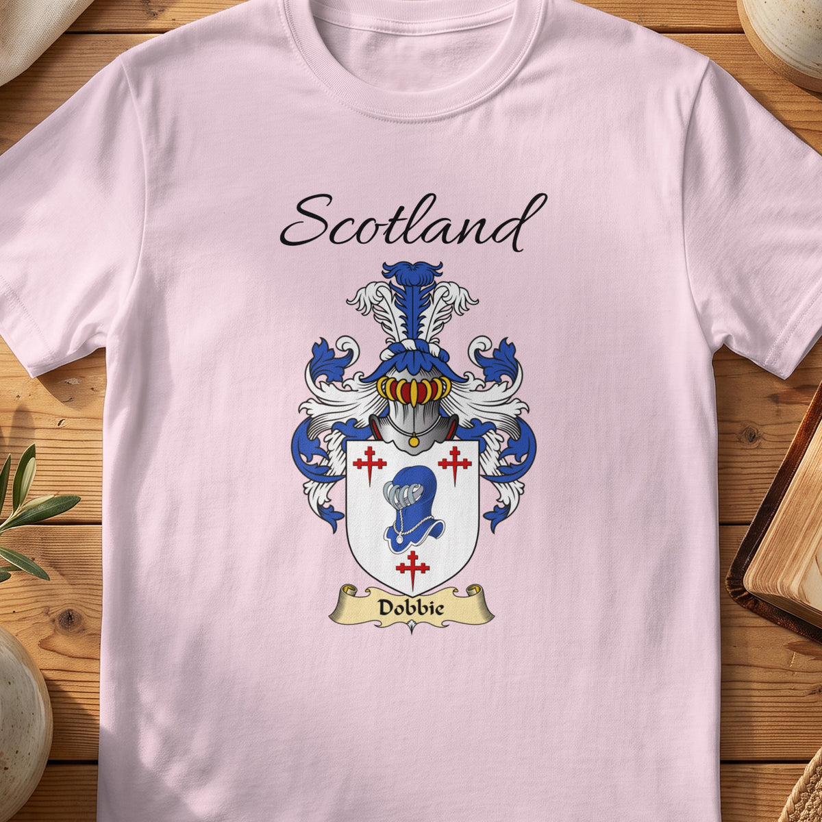 Light Pink Dobbie Scottish family shield T-shirt featuring a blue animal head surrounded by red crosses