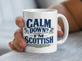 White mug with "Calm Down? I'm Scottish" and thistle designs.