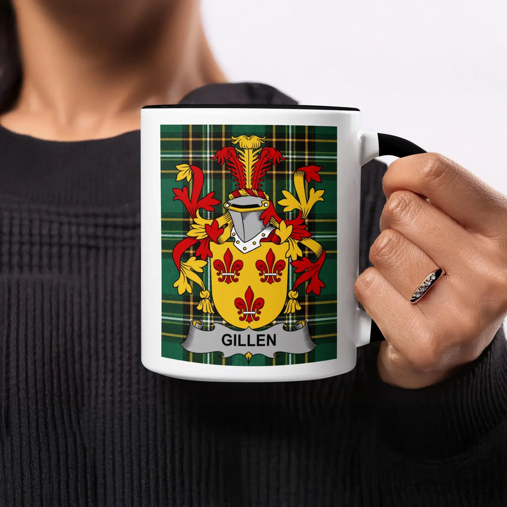 Gillen family crest on a white mug with black rim held by a person.