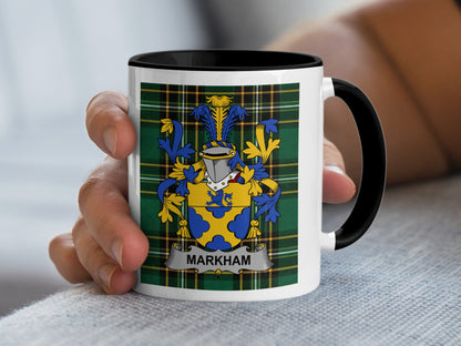 White mug with black handle featuring a family crest and "MARKHAM" text.
