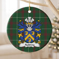 Aubrey ornament hanging from a pale branch; three gold eagle heads and a gold chevron on a blue shield on Welsh national tartan.