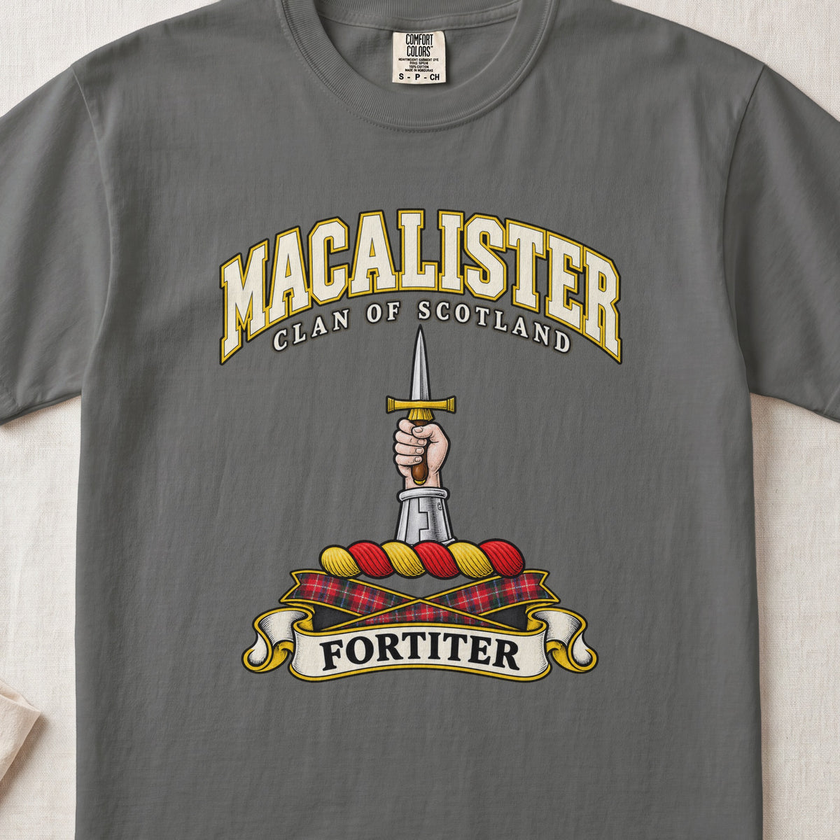 MacAlister Scottish clan T-shirt in Pepper, front view with an armored arm and hand holding an upright dagger and motto design.