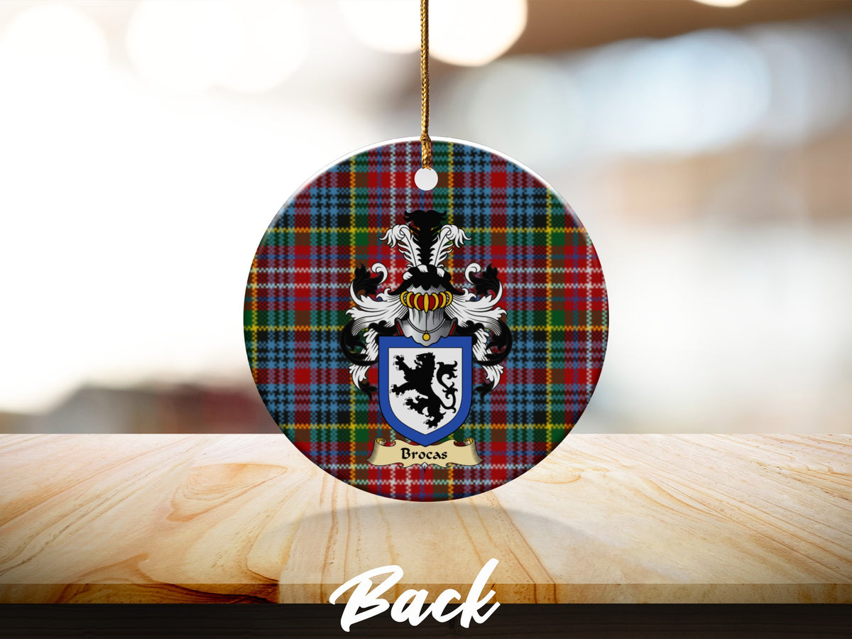 Round Brocas Scottish clan ornament with family crest on a Caledonia tartan background