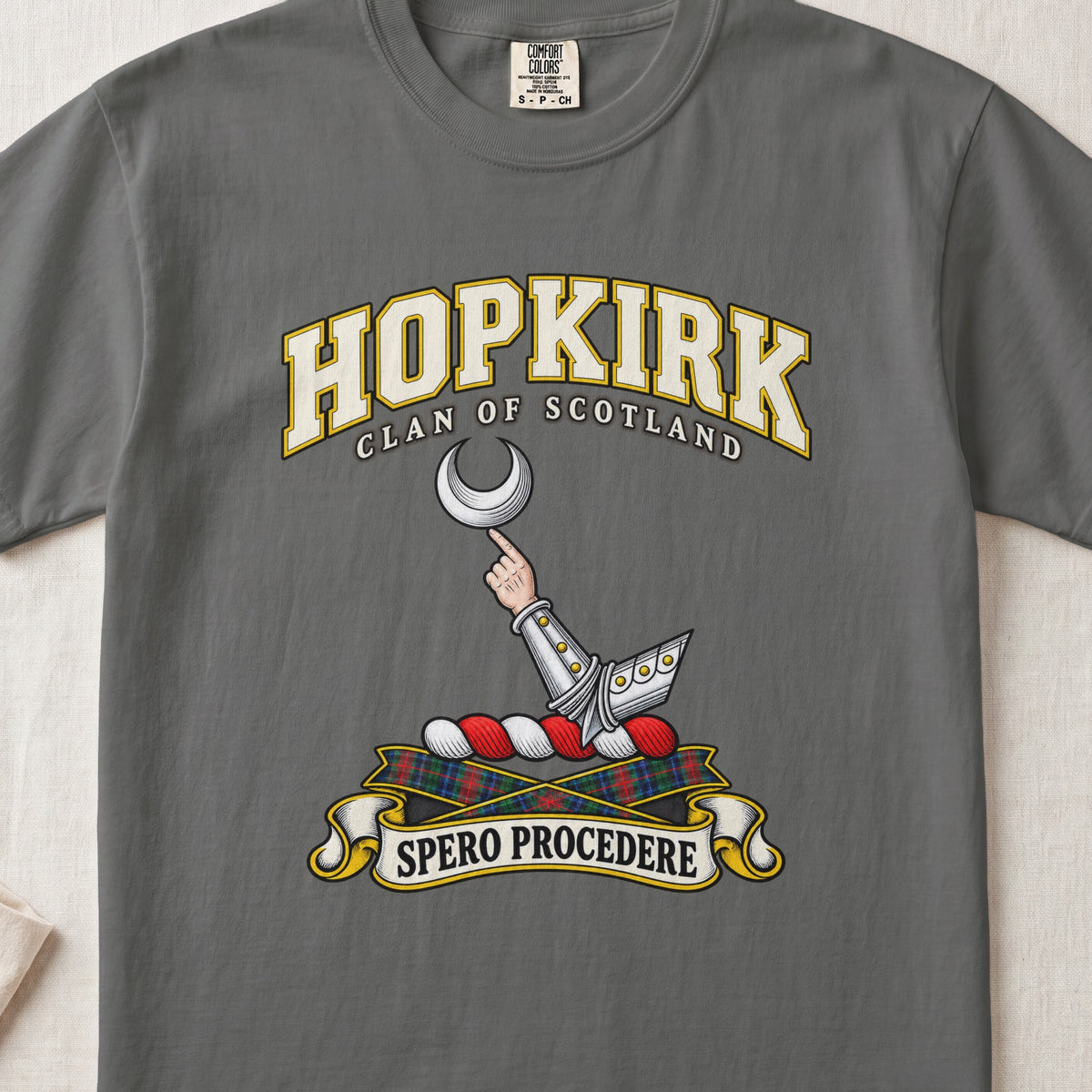 Hopkirk Scottish clan T-shirt in Pepper, front view with an armoured arm holding a silver crescent and motto banner.