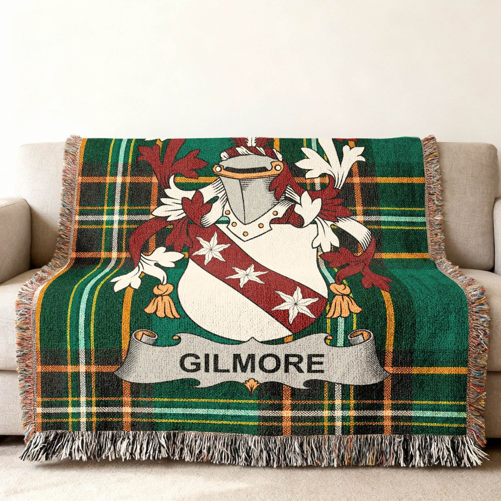 Green tartan blanket with Gilmore family crest draped on a sofa.