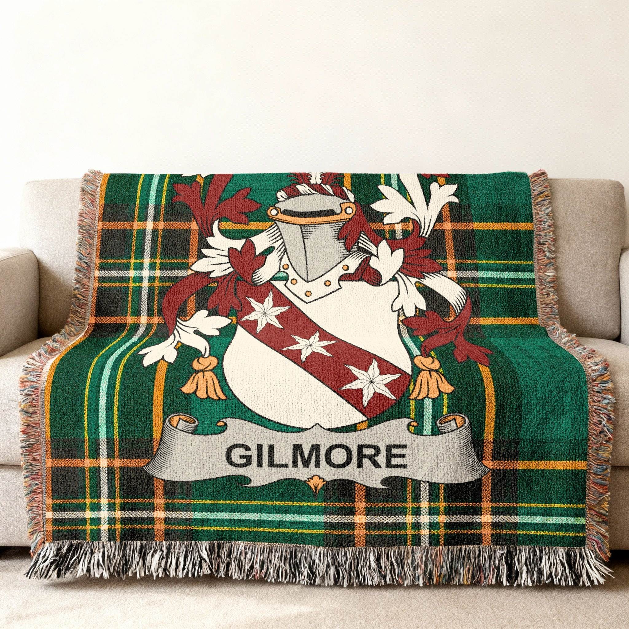Green tartan blanket with Gilmore family crest draped on a sofa.