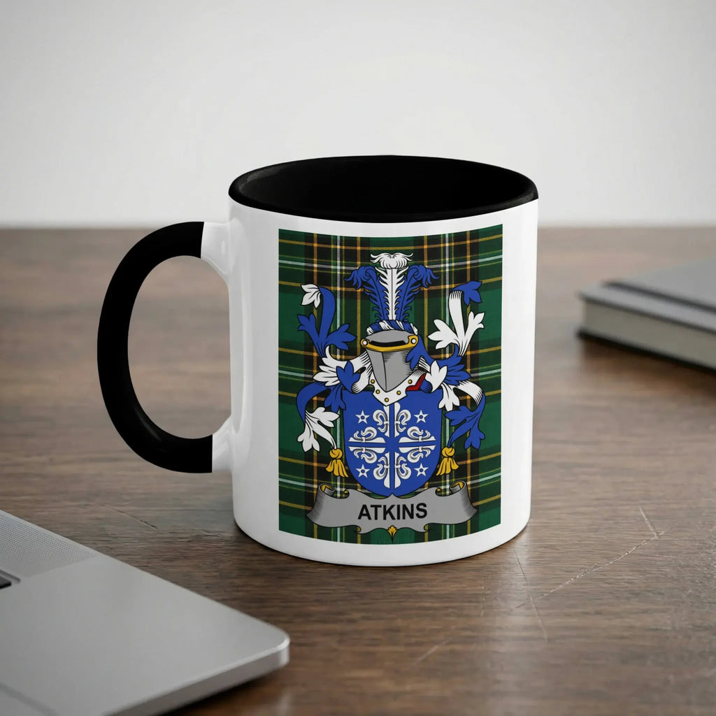 White mug with black interior featuring a blue and green crest with the name "ATKINS".