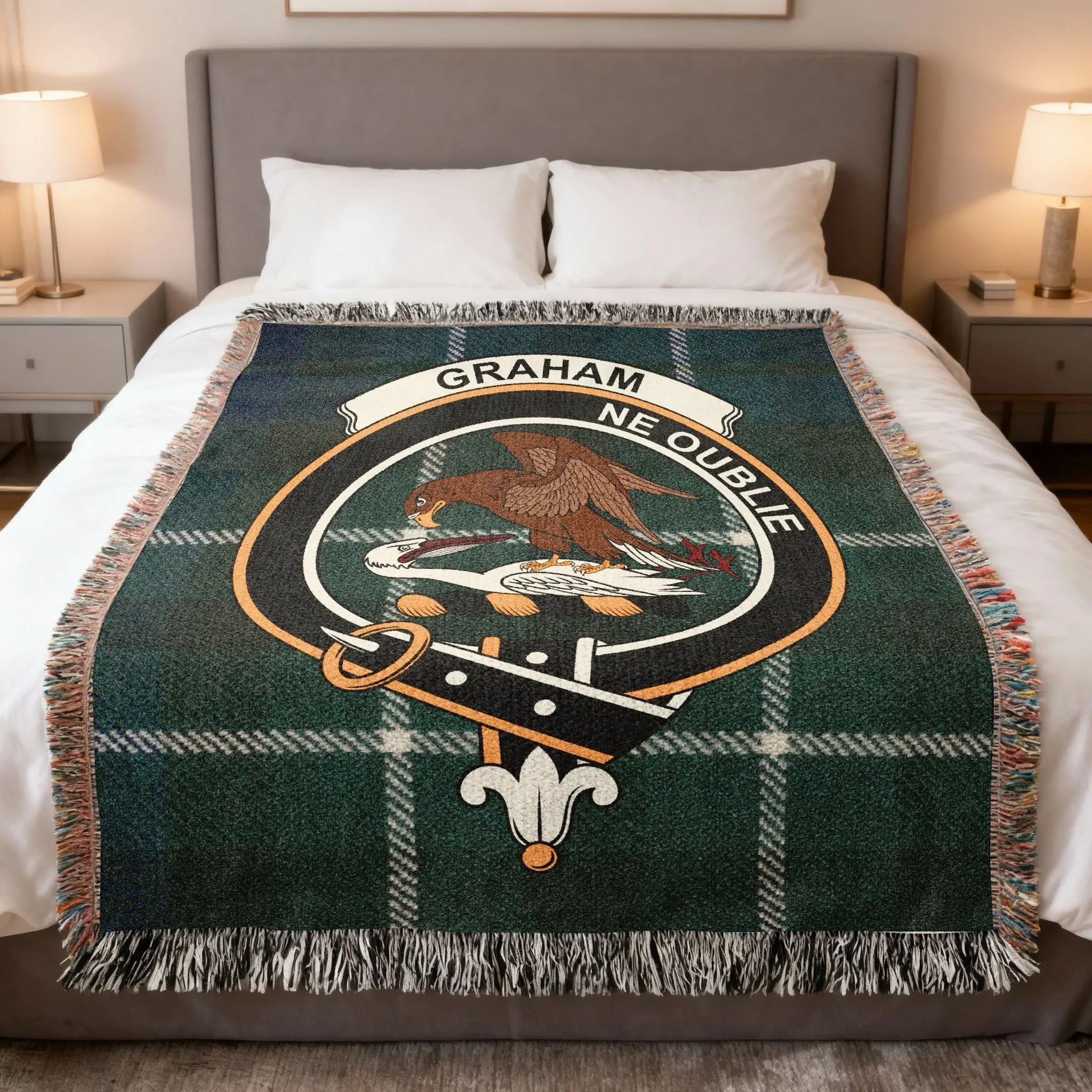 Clan Graham tartan woven cotton blanket — blue and green check with falcon crest, draped on sofa