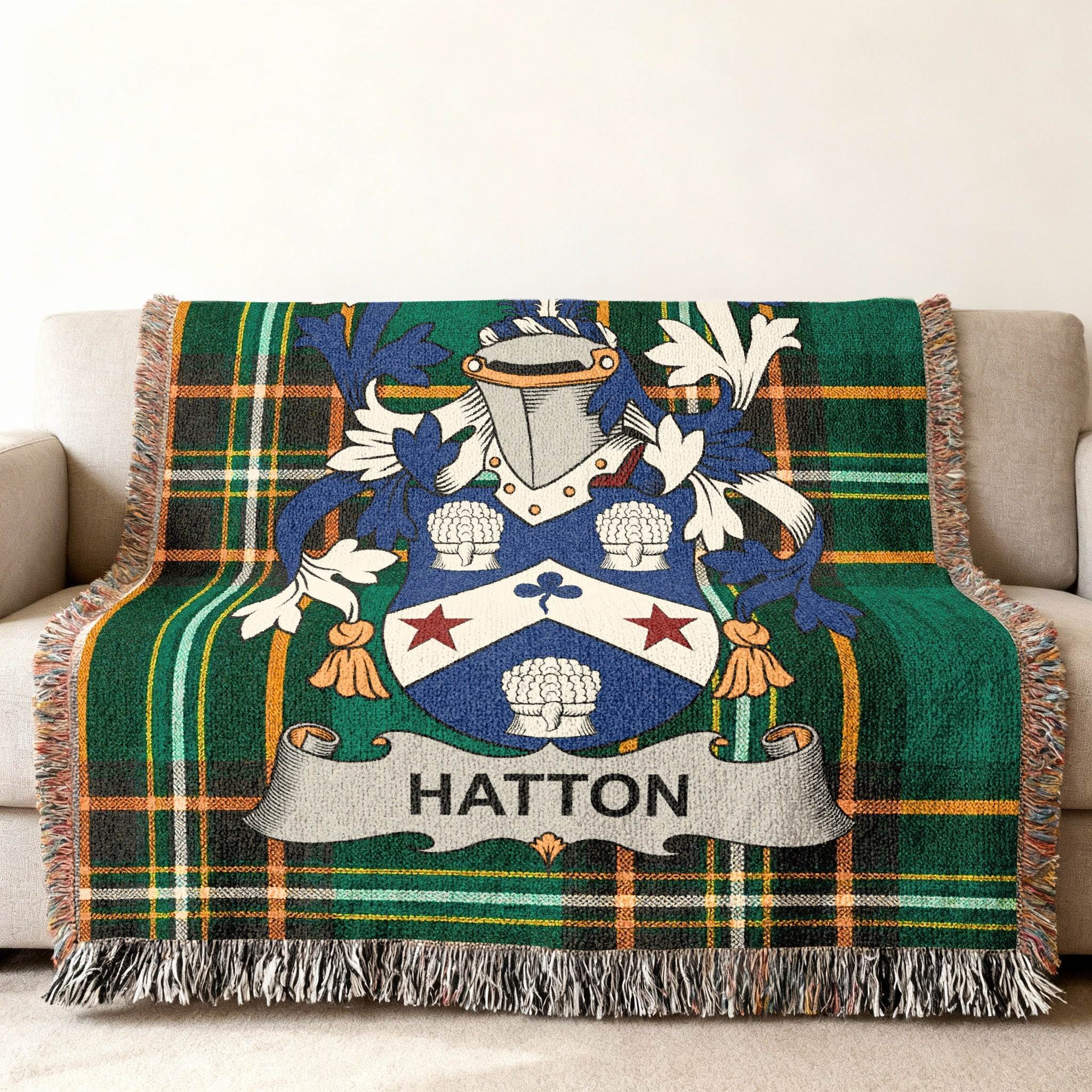 Hatton family crest on a green tartan blanket draped over a sofa.