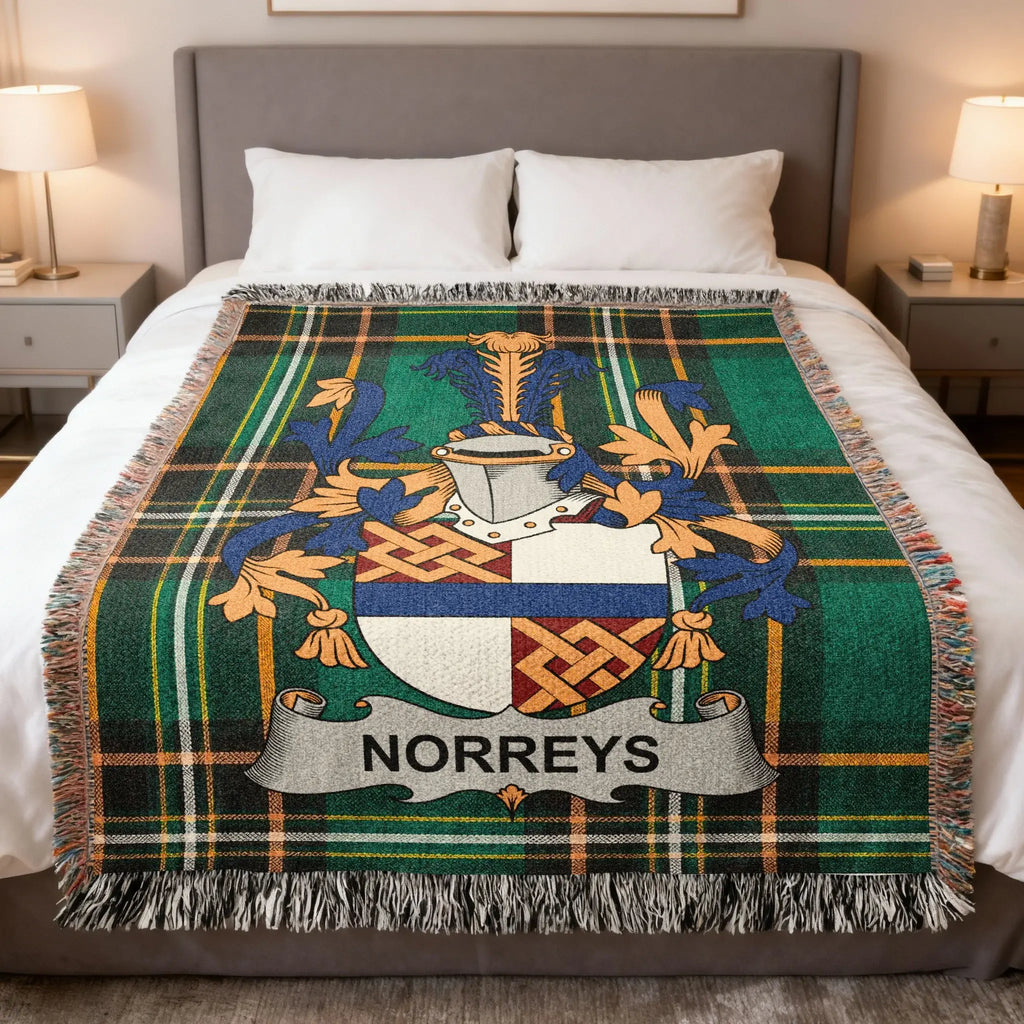 Green tartan throw blanket with Norreys family crest on a bed.