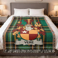 Tartan blanket with Vere family crest on a bed.