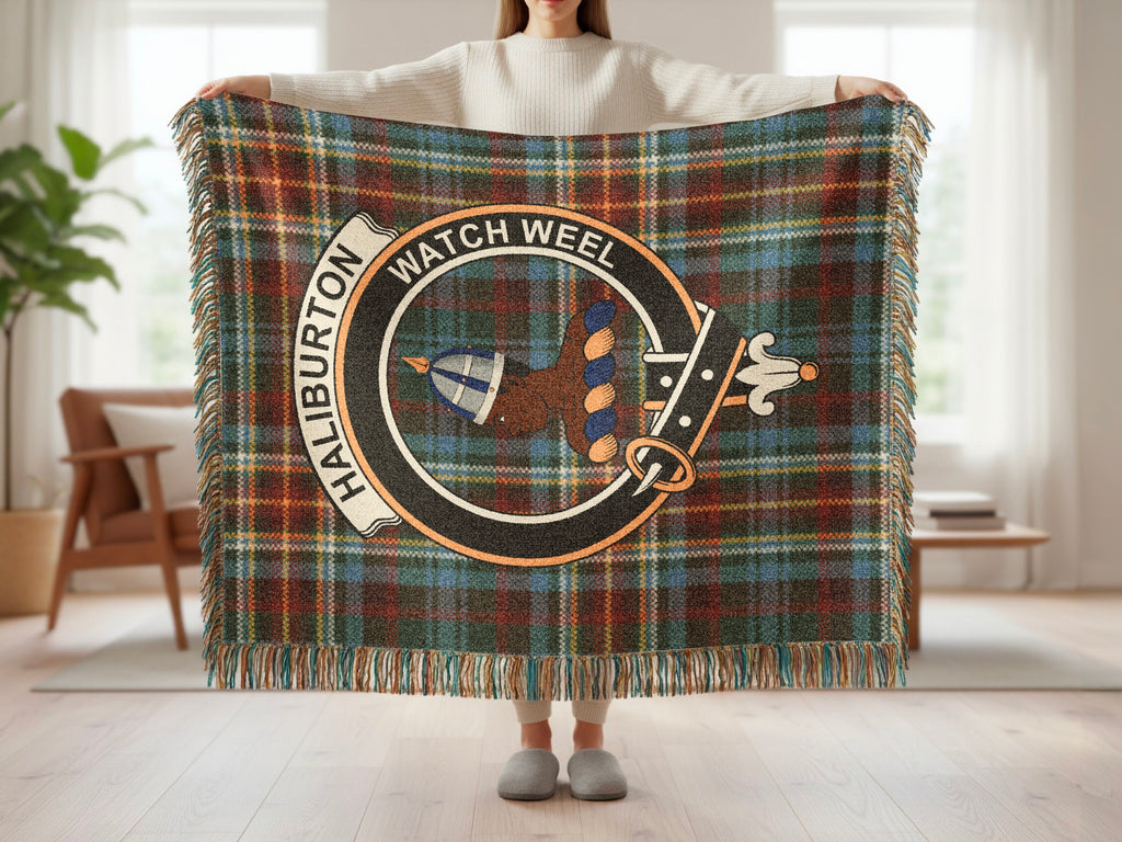 Person holding the Haliburton woven blanket to show the full design, tartan background and fringe