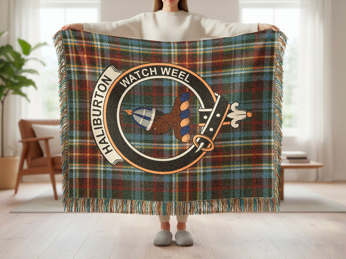 Person holding the Haliburton woven blanket to show the full design, tartan background and fringe