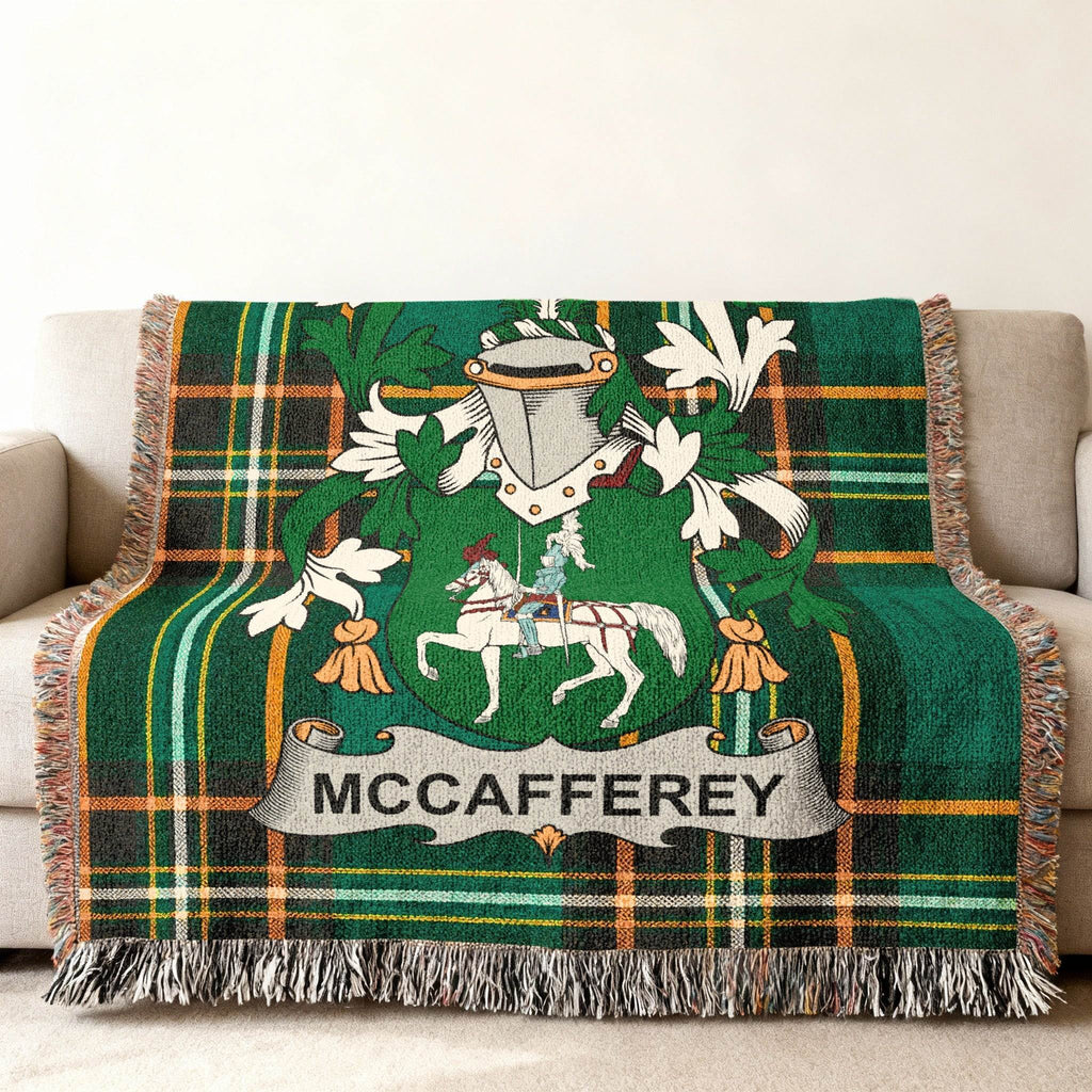 Green tartan throw blanket with McCaffrey family crest featuring a knight on horseback.