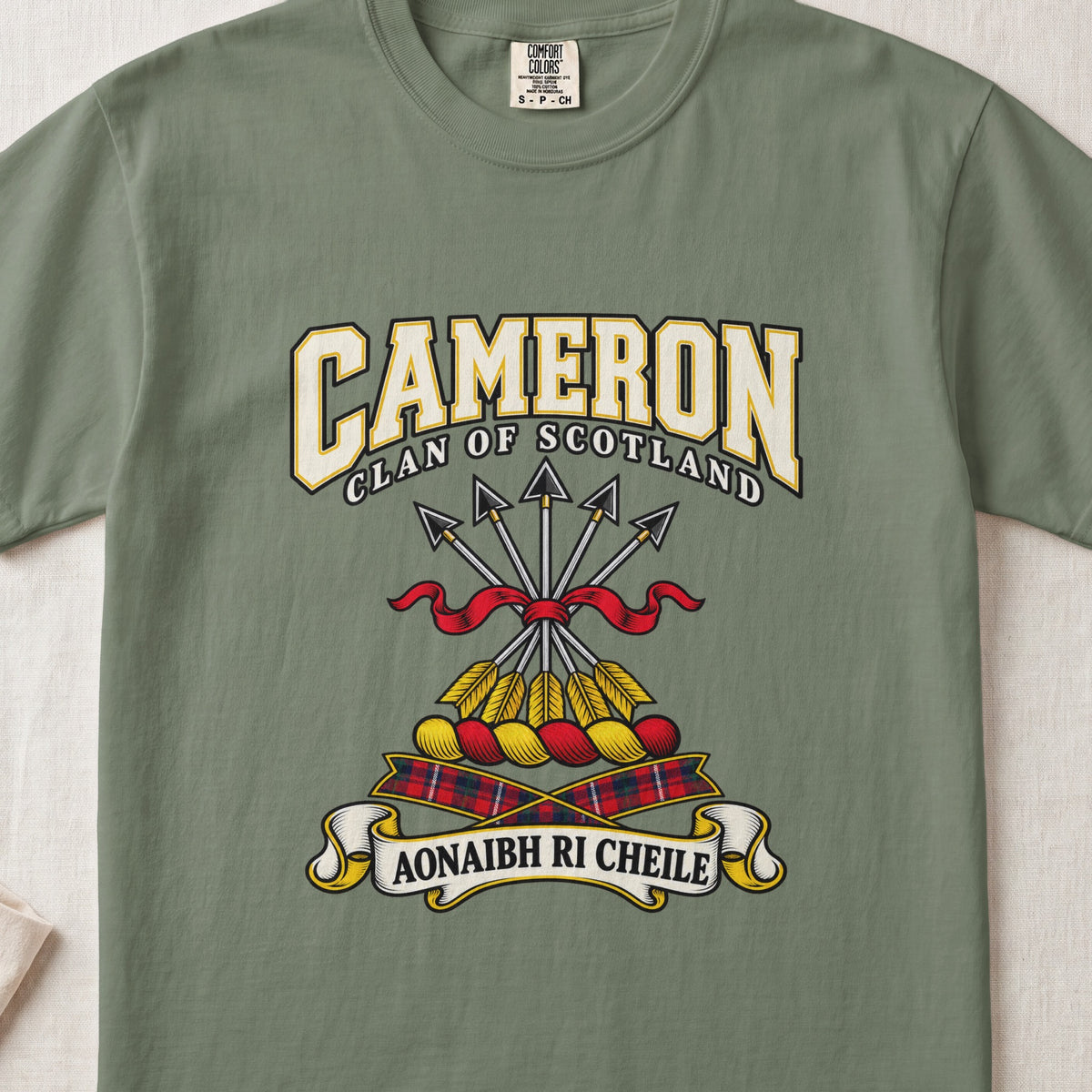 Cameron graphic T-shirt in Moss green, front flat lay showing varsity lettering and five arrows tied with red ribbon.