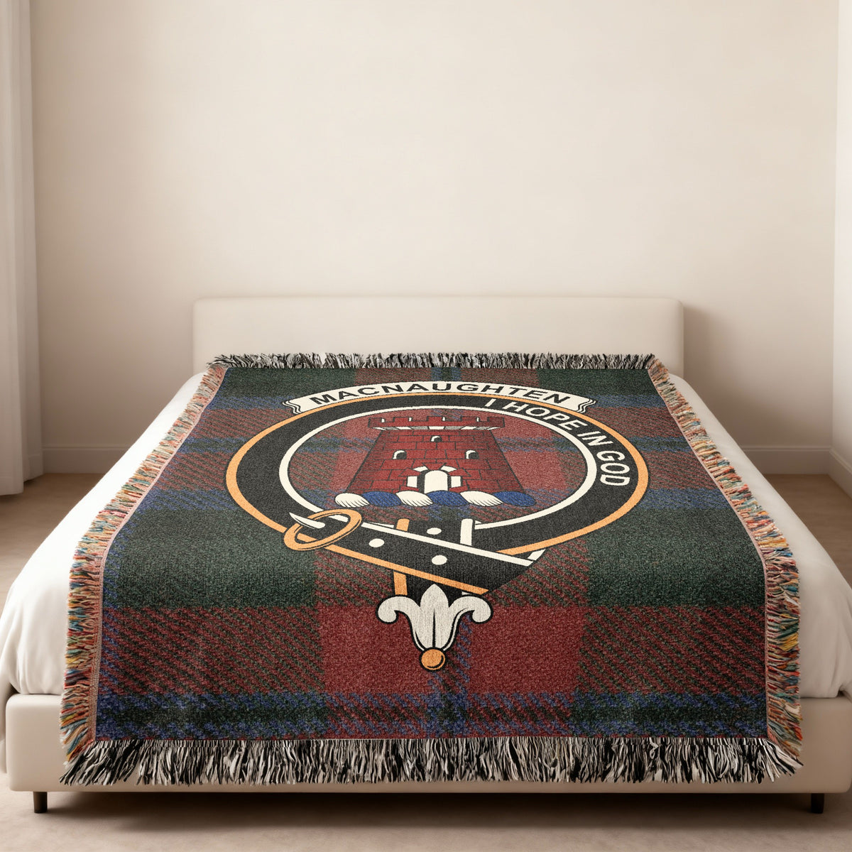 MacNaughten Scottish woven blanket spread across a bed, showing the full crest design and tartan background