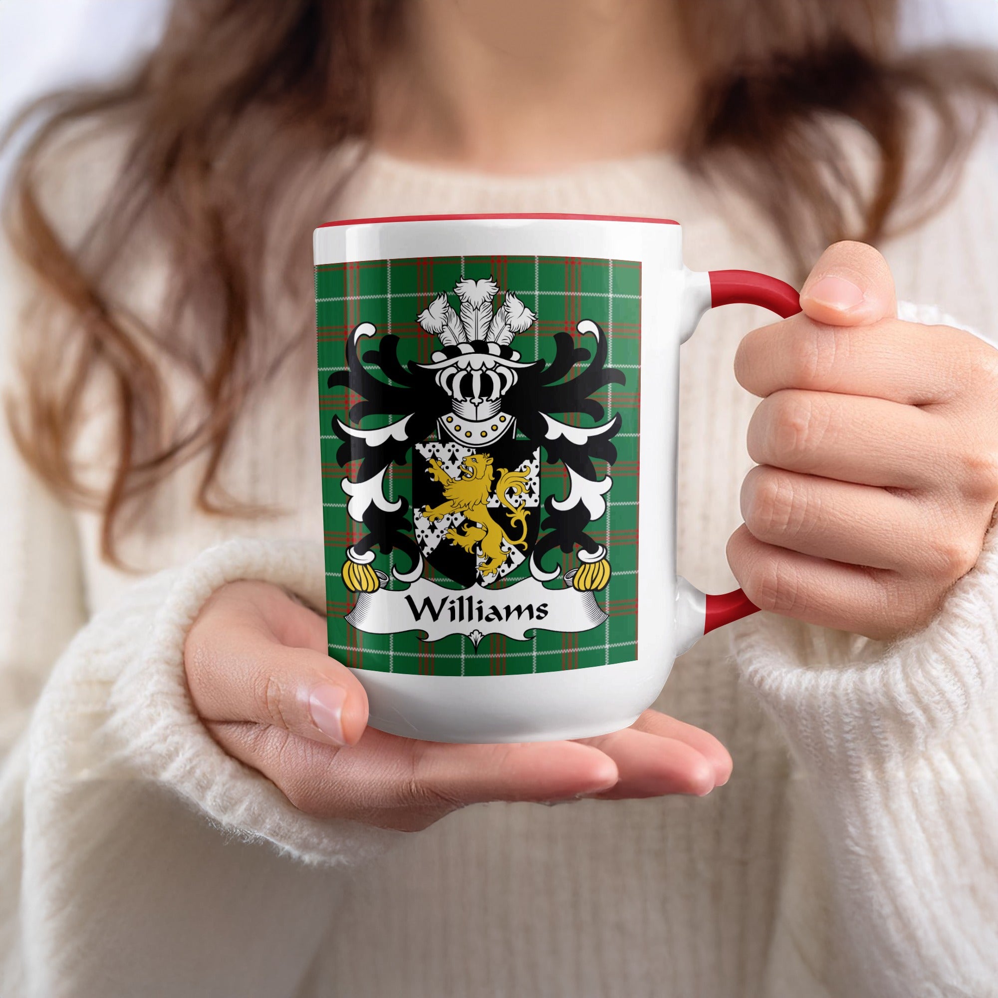 White mug with red trim displaying the Williams family crest on a green tartan background.